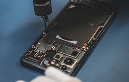 Telefon z widocznymi komponentami, widoczna płyta główna i aparaty.