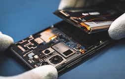 Telefon z widocznymi komponentami, widoczna bateria i płyta główna.